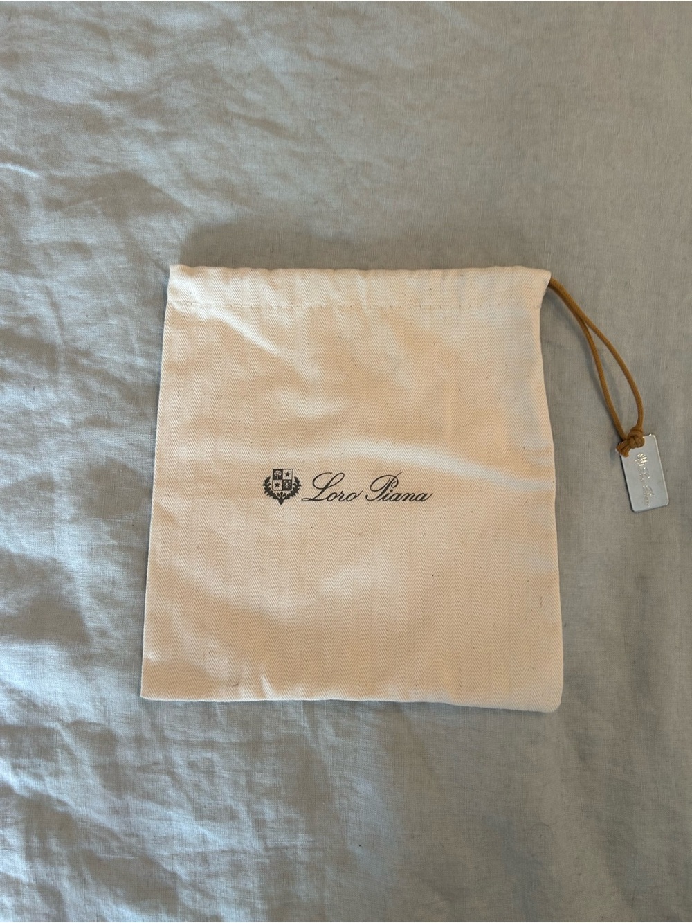 Loro Piana belt dust bag with silver charm.